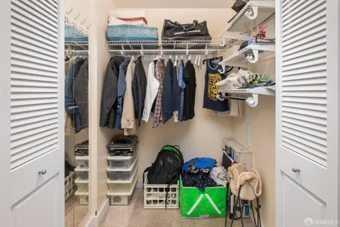 a view of walk in closet with clothes and shoes