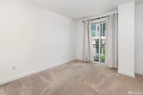 an empty room with floor to ceiling window and an entryway
