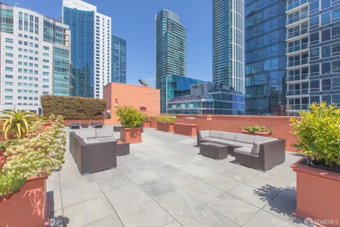 a view of a patio with a dining table and chairs with potted plants