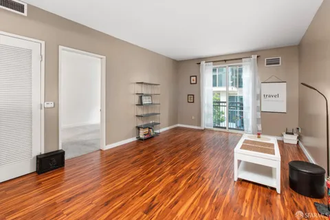 a spacious bedroom with a bed and a wooden floor