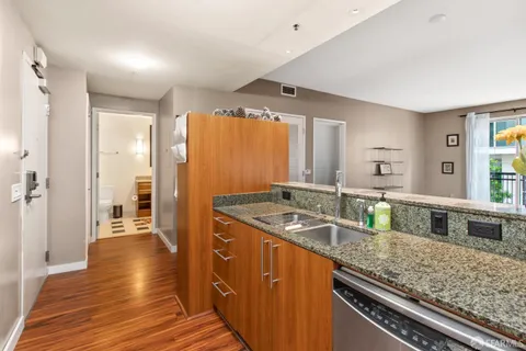 a kitchen with granite countertop a sink stove and cabinets