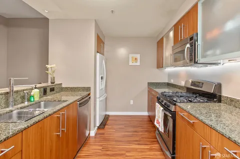 a kitchen with stainless steel appliances granite countertop a stove a sink and a refrigerator