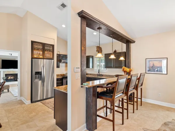 a large kitchen with stainless steel appliances granite countertop a sink and a refrigerator