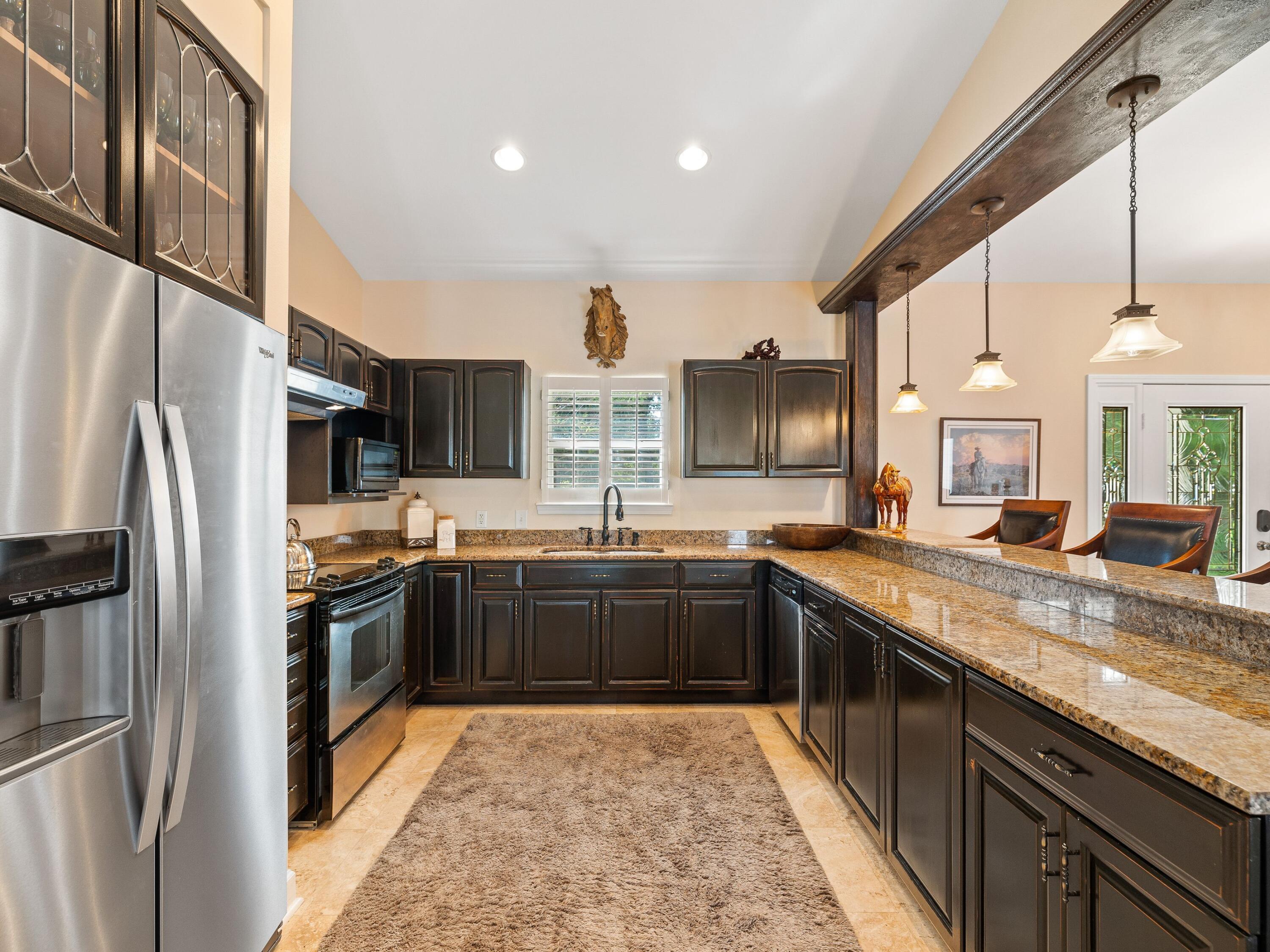 5676 Highway 2 DeFuniak Springs, FL 32433 - Photo 13 of 42 a large kitchen with stainless steel appliances granite countertop a sink and a refrigerator