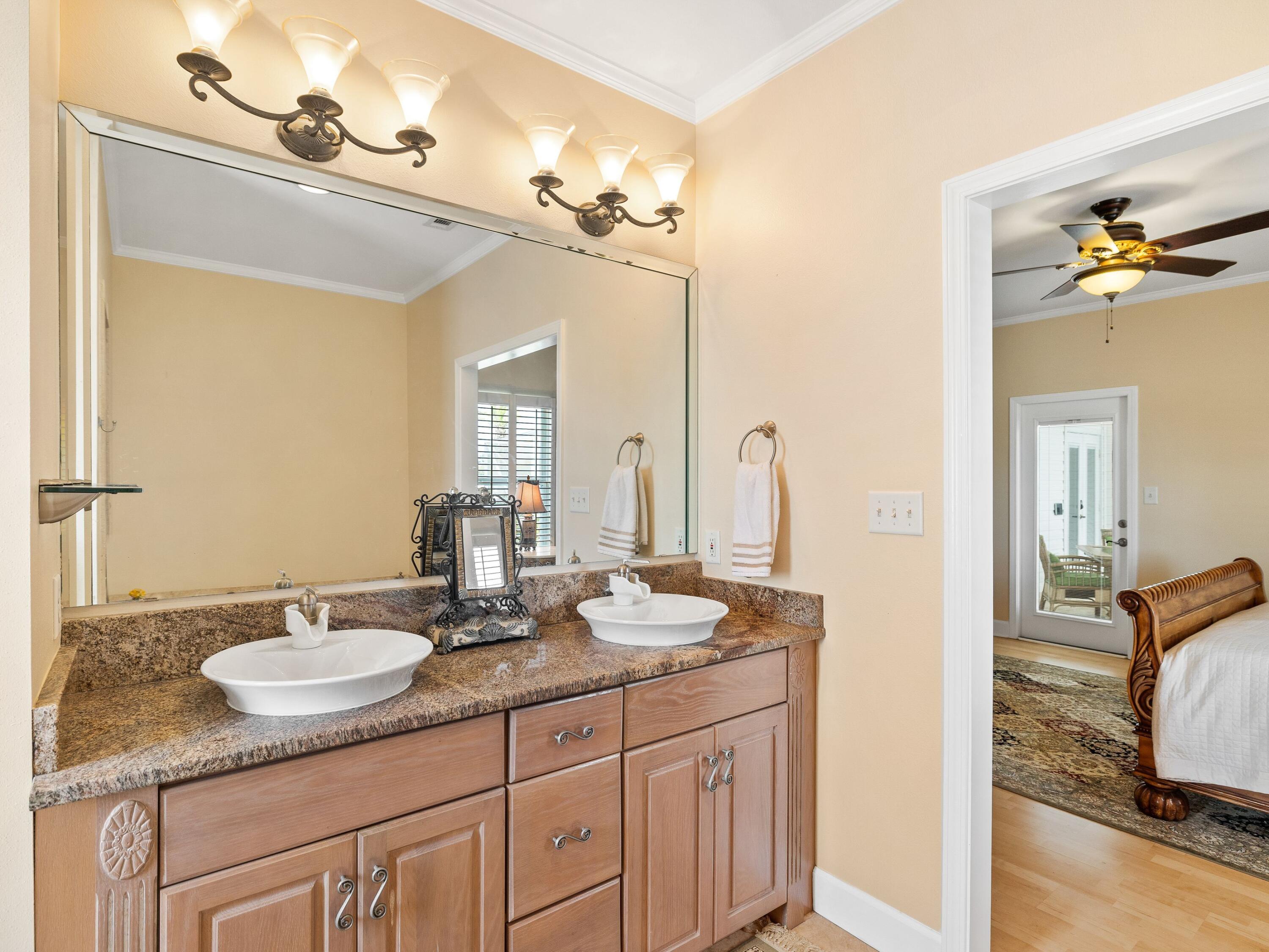 5676 Highway 2 DeFuniak Springs, FL 32433 - Photo 18 of 42 a bathroom with double vanity sinks a vanity a lamp and a mirror