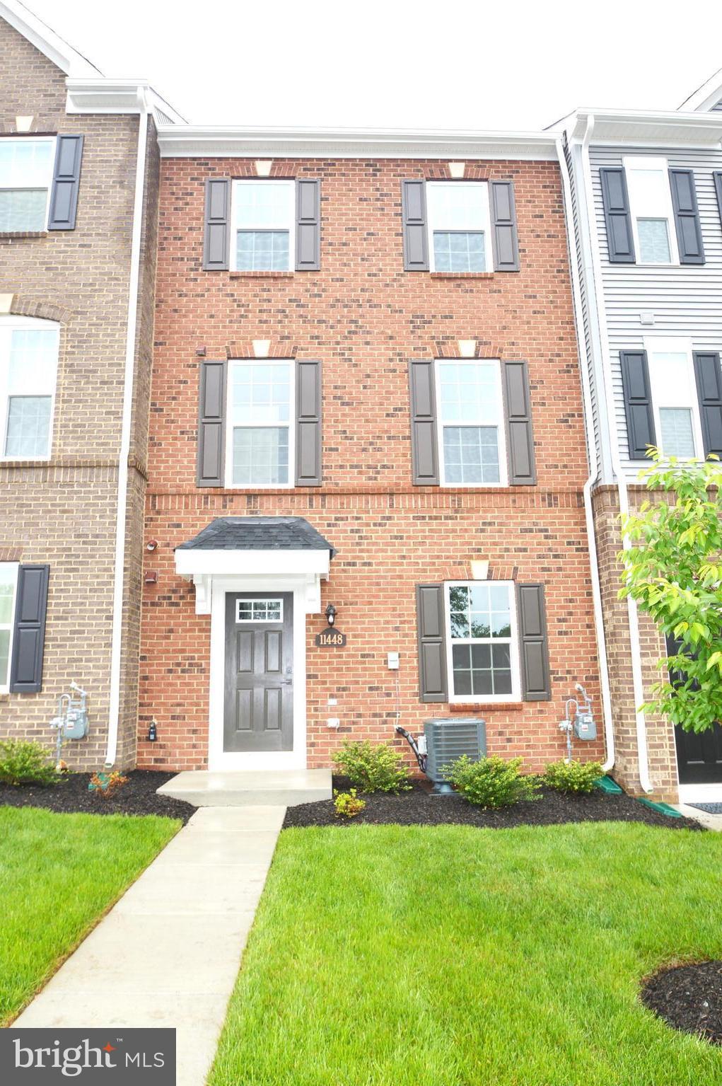11448 Willow Green Circle Manassas, VA 20109 - Photo 1 of 26 front view of a brick house and a yard with large windows