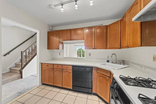 a kitchen with a sink stove top oven and cabinets