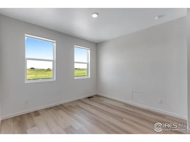 an empty room with windows and closet