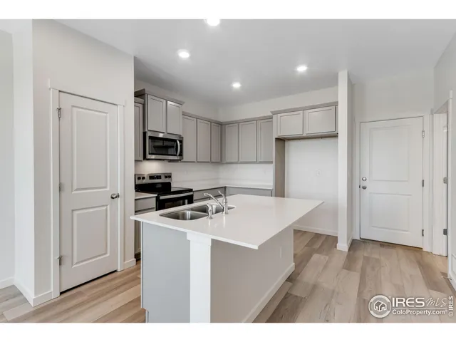 a kitchen with kitchen island a sink stainless steel appliances and cabinets