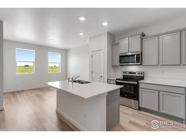 a kitchen with kitchen island white cabinets appliances and a sink