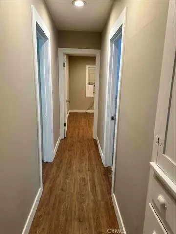 a view of a room with wooden floor and a bathroom