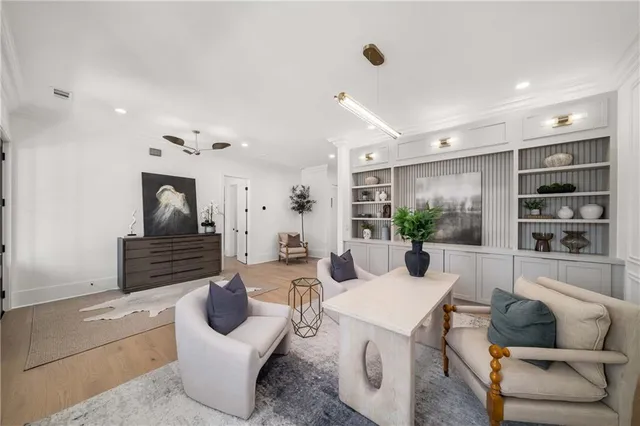 a dining room with furniture a chandelier and glass door