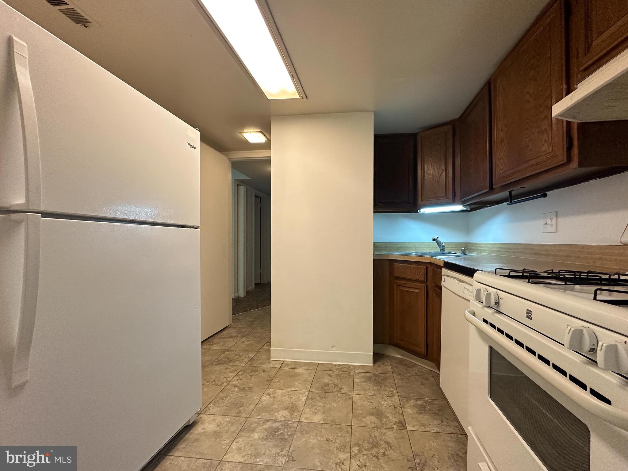1532 Northgate Square, Unit 15322A Reston, VA 20190 - Photo 11 of 16 a view of a kitchen with a refrigerator a stove top oven and cabinets