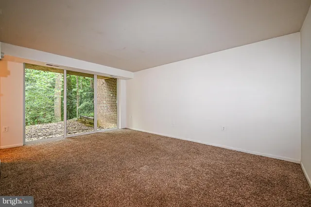 a view of an empty room with large windows