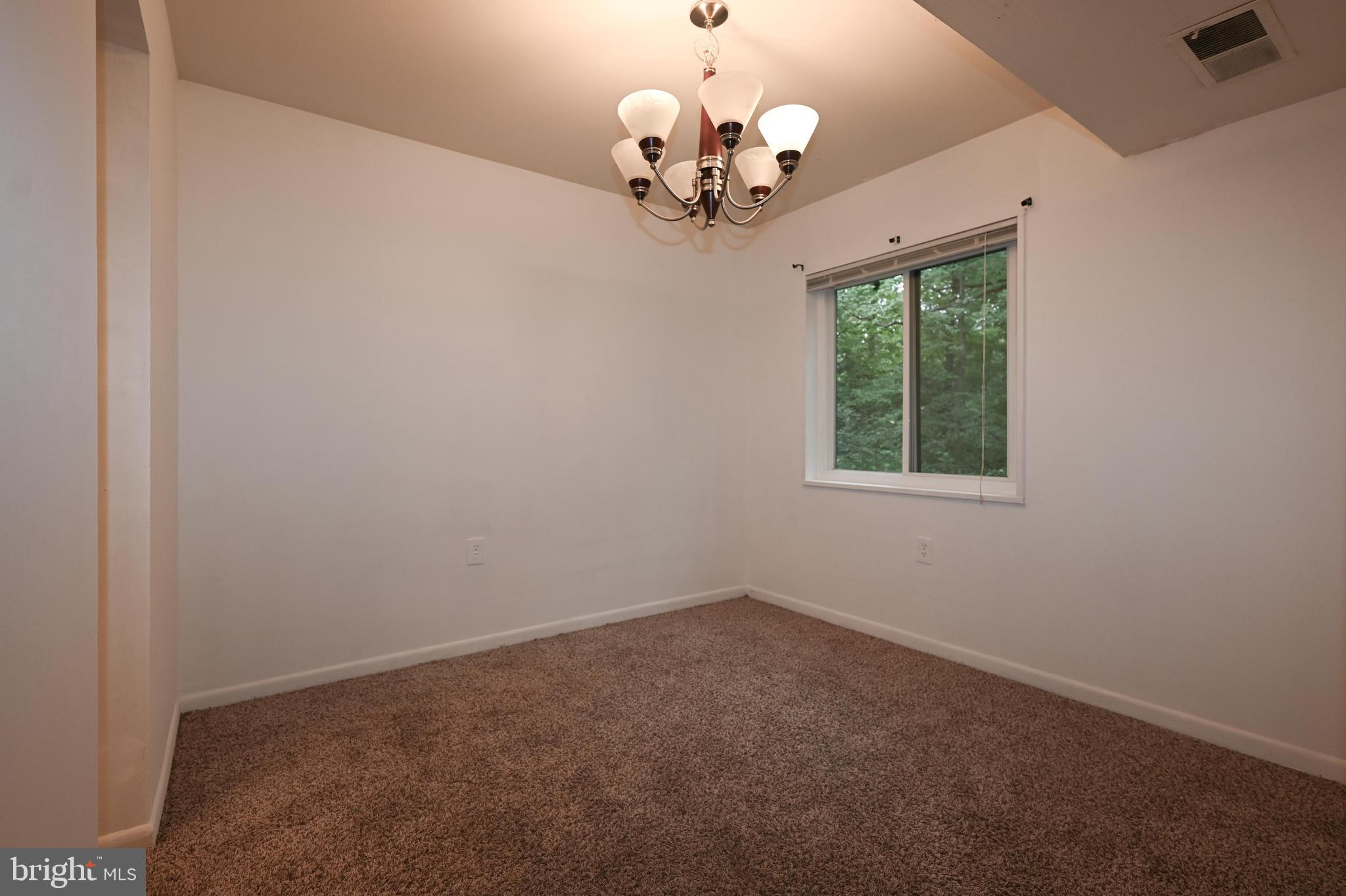 1532 Northgate Square, Unit 15322A Reston, VA 20190 - Photo 5 of 16 an empty room with a chandelier fan and a window