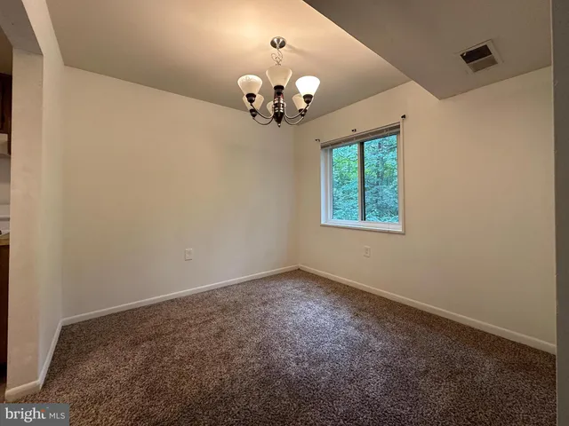 an empty room with a chandelier fan and closet