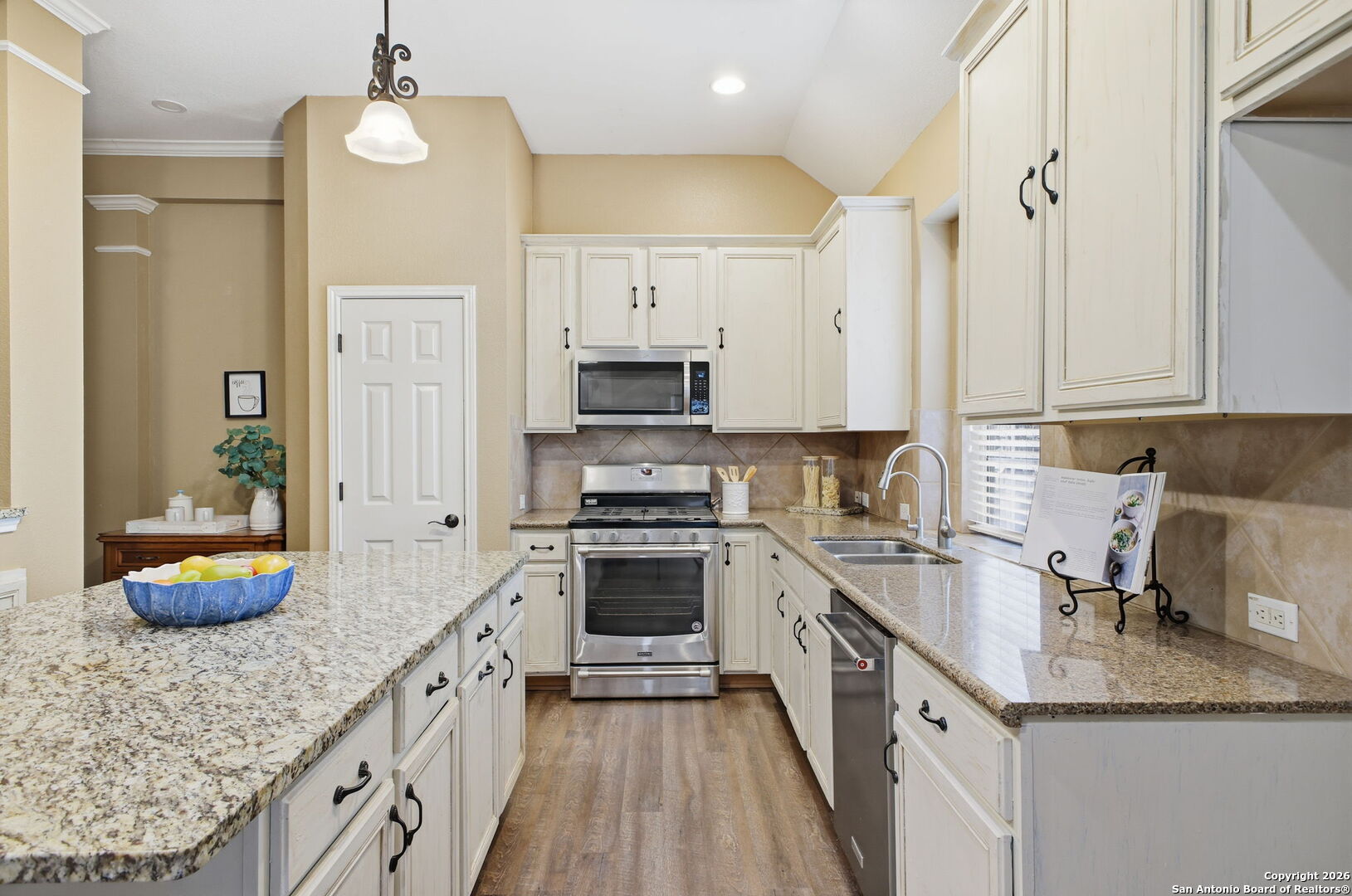 527 Mesa Ridge San Antonio, TX 78258 - Photo 11 of 25 a kitchen with granite countertop a sink a counter space appliances and cabinets
