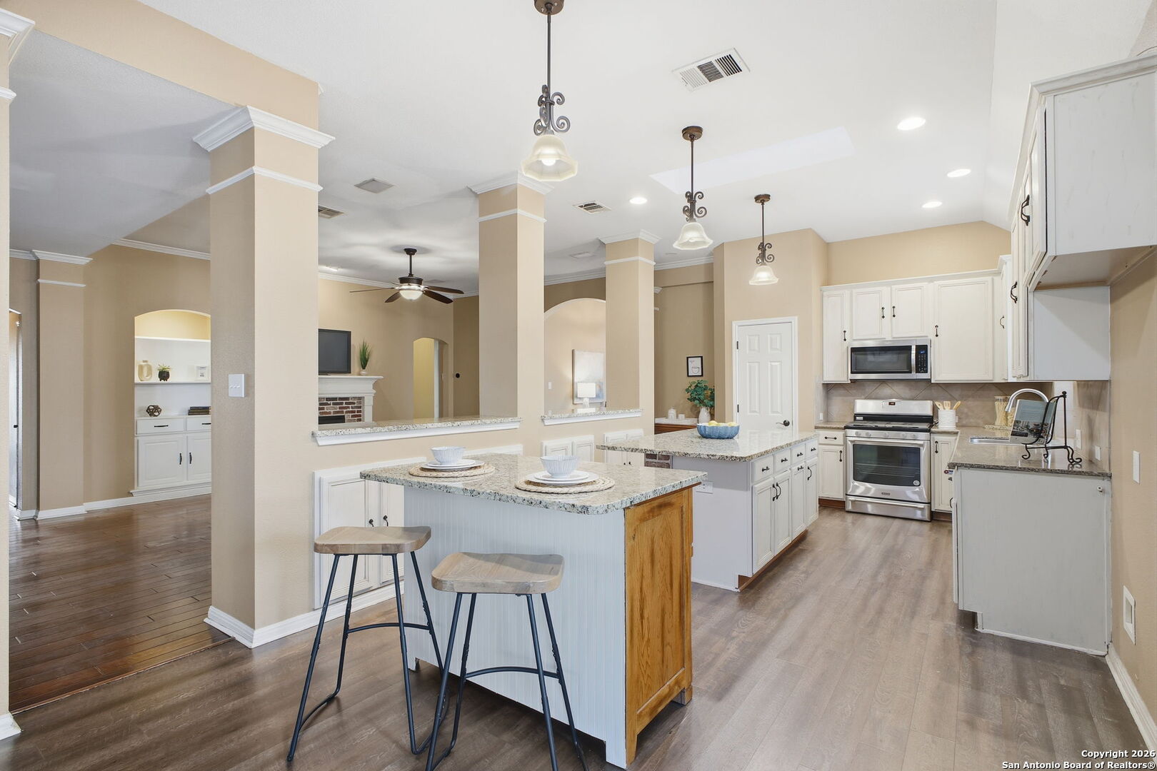 527 Mesa Ridge San Antonio, TX 78258 - Photo 17 of 36 a kitchen with stainless steel appliances kitchen island a refrigerator a stove a sink and chairs