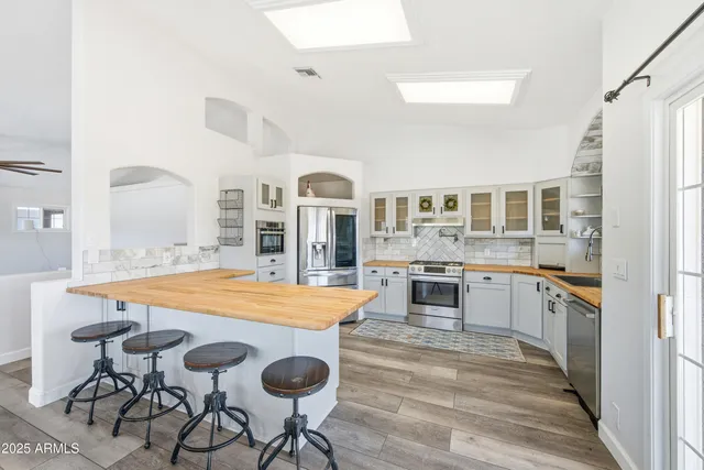 a large kitchen with cabinets wooden floor and stainless steel appliances