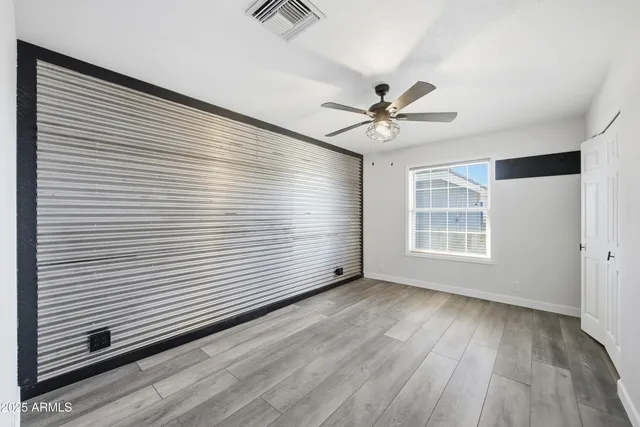a view of a room with wooden floor and a ceiling fan
