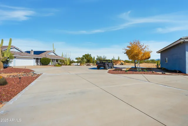 a view of a patio with couches table and chairs under an umbrella with a small yard