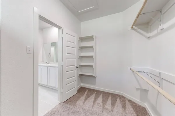 a view of walk in closet with empty racks