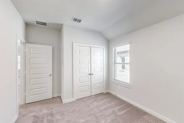 an empty room with windows and closet