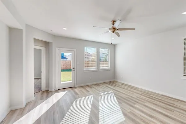 a view of a bedroom with wooden floor and windows