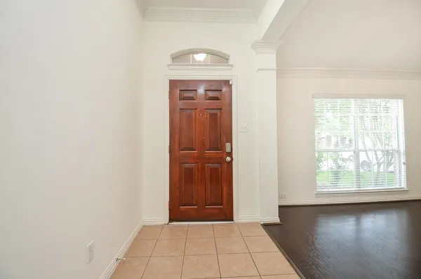an empty room with wooden floor cabinet and windows