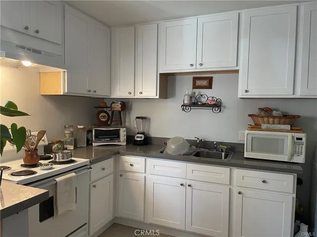 a kitchen with white cabinets and white appliances