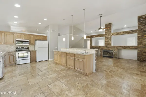 a large kitchen with kitchen island a sink stainless steel appliances and cabinets