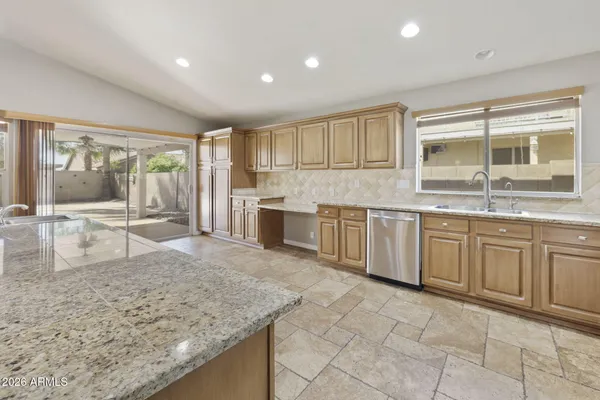 a kitchen with granite countertop white cabinets and stainless steel appliances