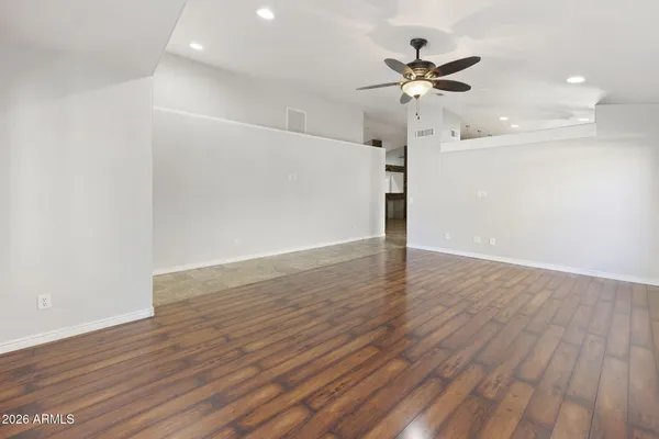 a view of an empty room with a window and wooden floor