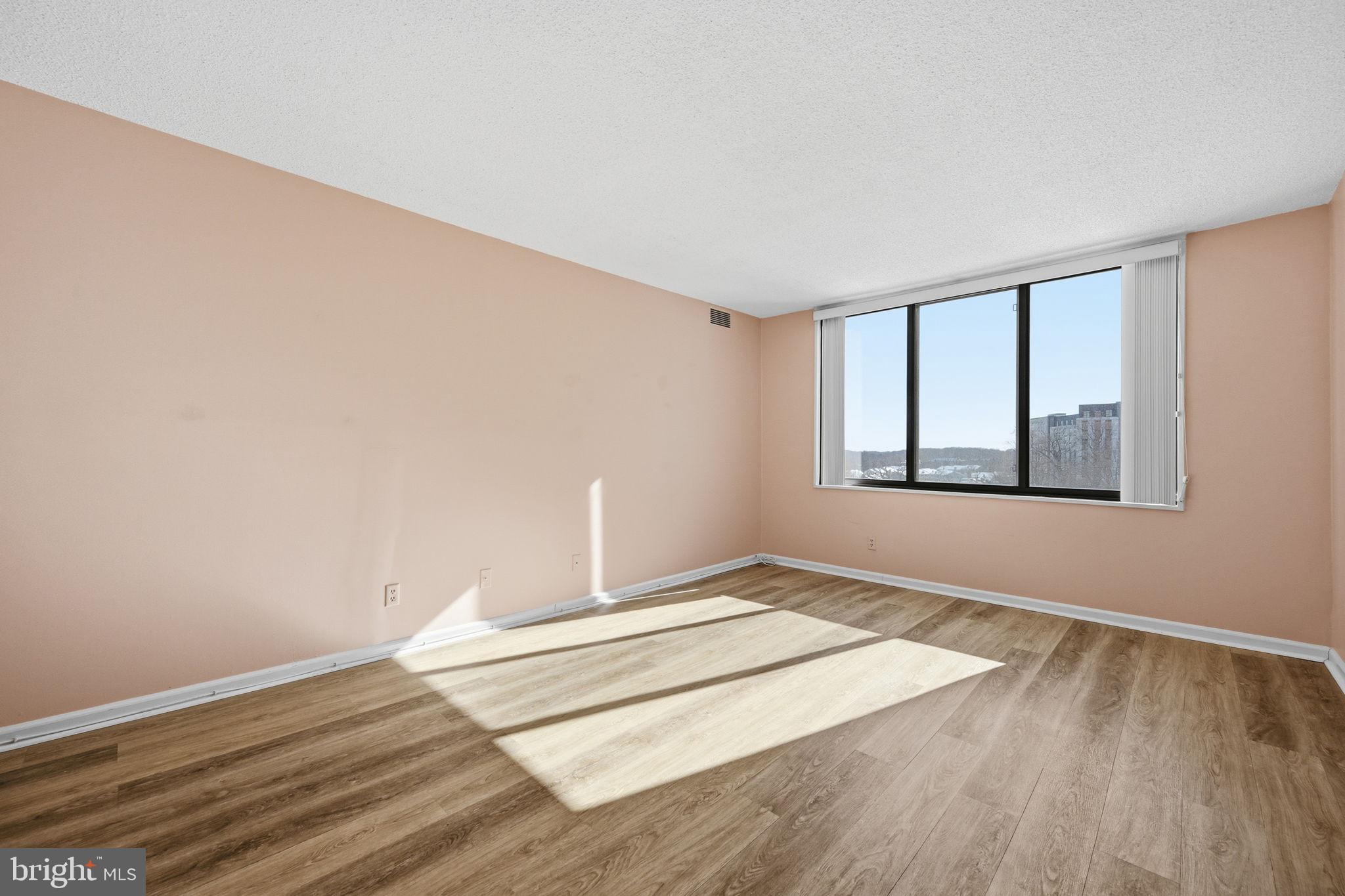 5225 Pooks Hill Road, Unit 519N Bethesda, MD 20814 - Photo 16 of 56 a view of an empty room with wooden floor and a window