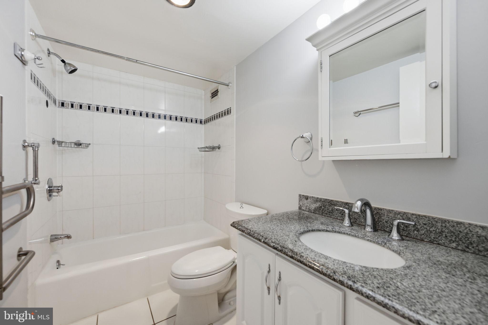 5225 Pooks Hill Road, Unit 519N Bethesda, MD 20814 - Photo 19 of 56 a bathroom with a granite countertop sink mirror toilet and bathtub