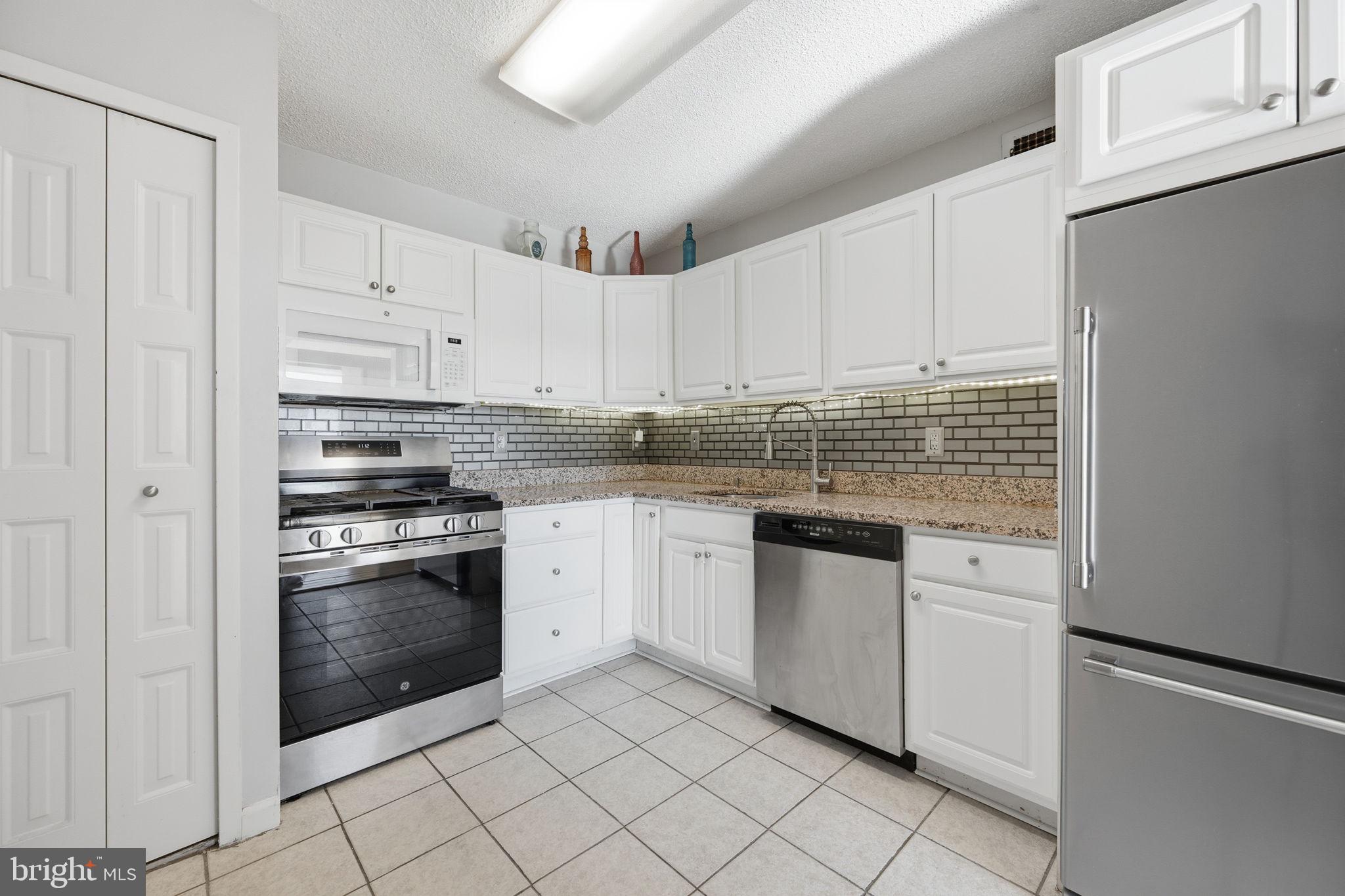 5225 Pooks Hill Road, Unit 519N Bethesda, MD 20814 - Photo 3 of 56 a kitchen with granite countertop white cabinets and stainless steel appliances