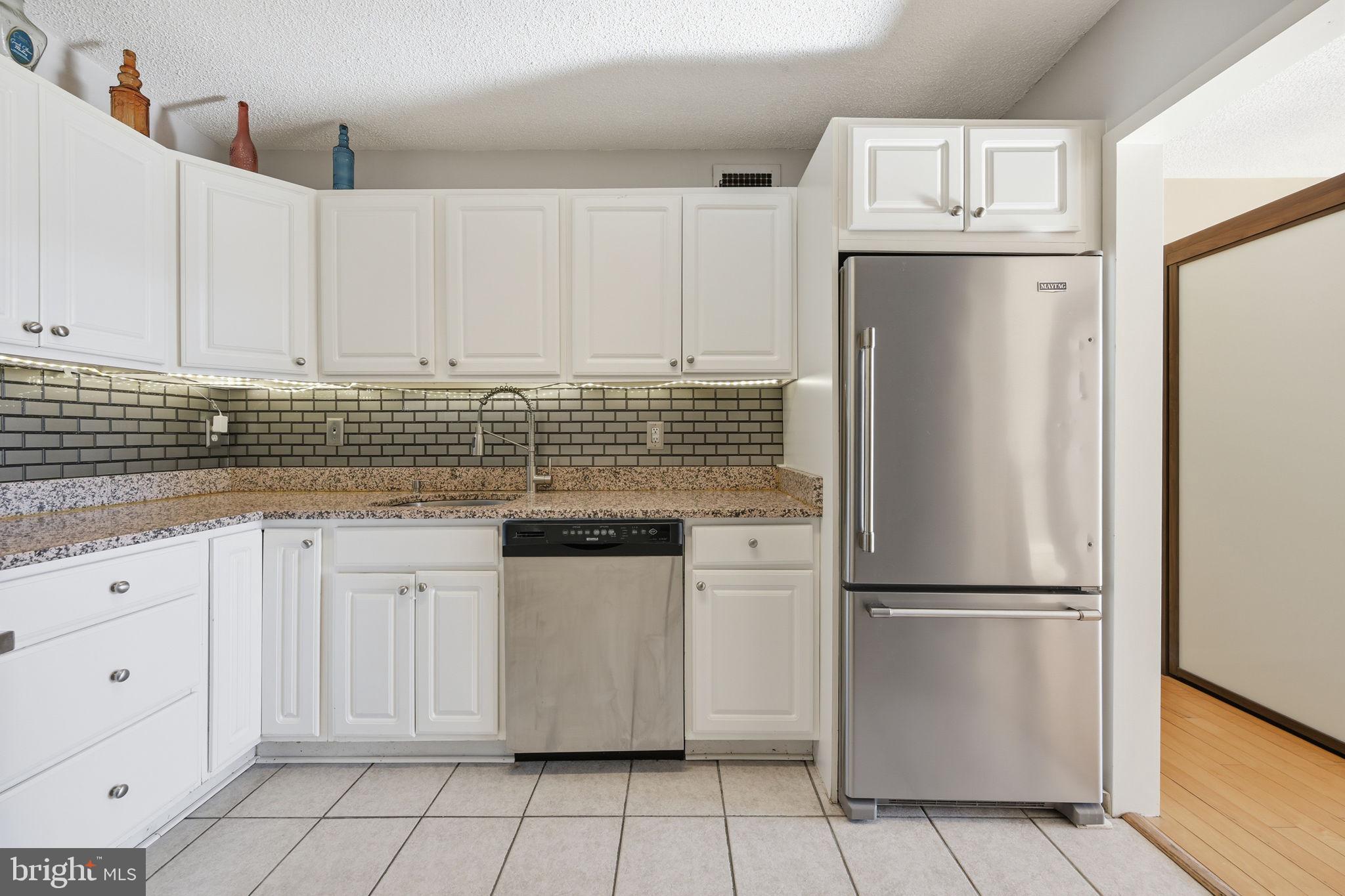 5225 Pooks Hill Road, Unit 519N Bethesda, MD 20814 - Photo 4 of 56 a kitchen with white cabinets and refrigerator