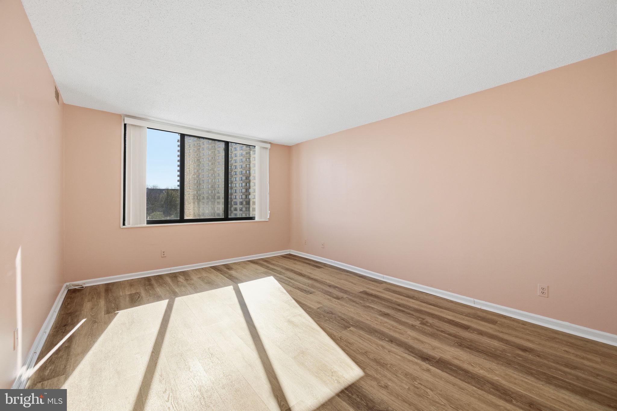5225 Pooks Hill Road, Unit 519N Bethesda, MD 20814 - Photo 6 of 56 a view of an empty room with wooden floor and a window
