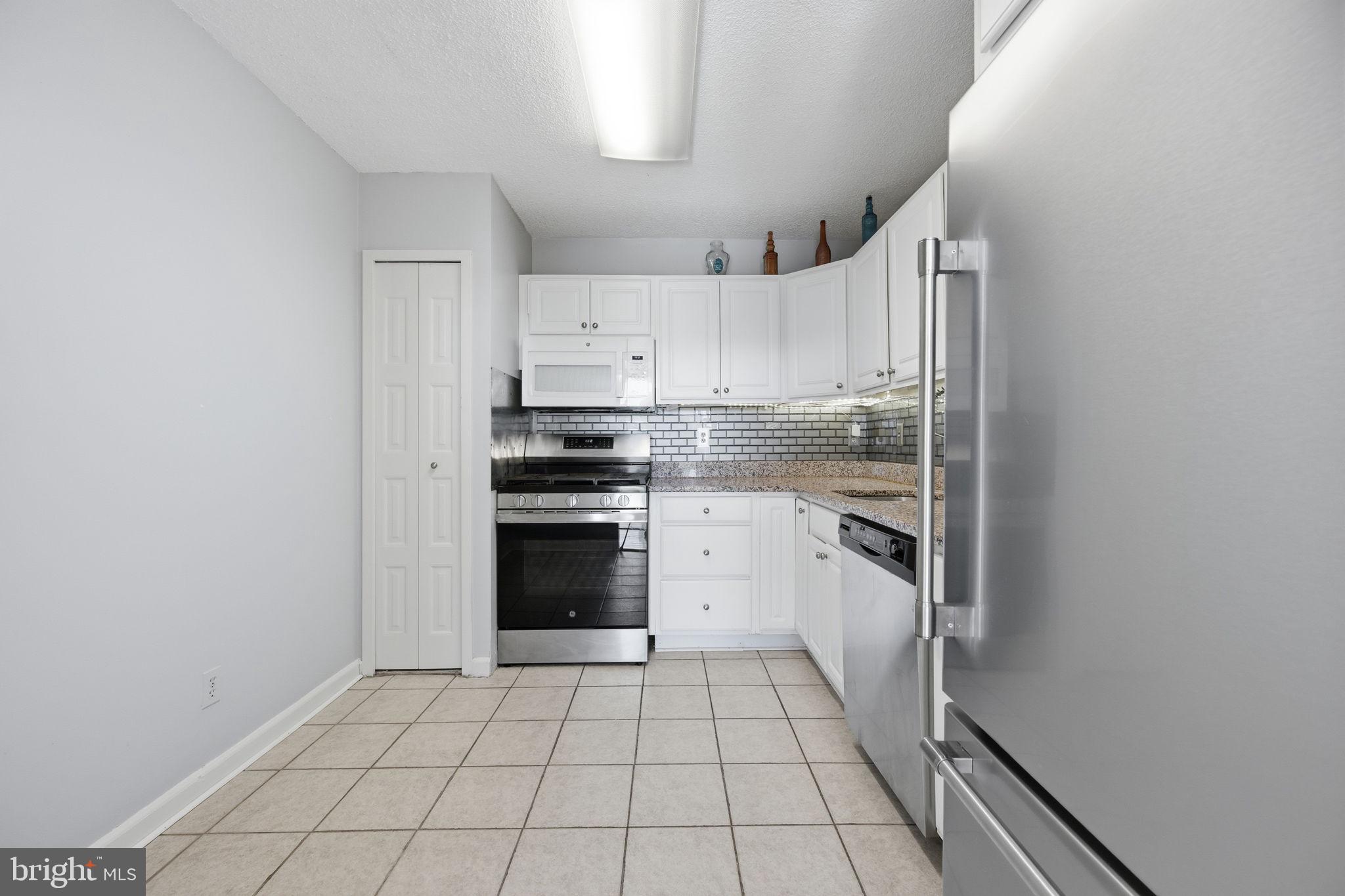 5225 Pooks Hill Road, Unit 519N Bethesda, MD 20814 - Photo 8 of 56 a kitchen with white cabinets and appliances