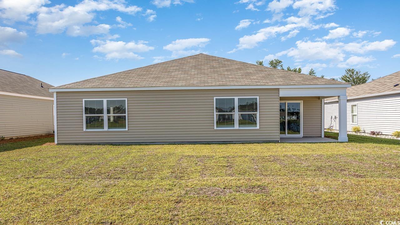 315 Skyward Street Myrtle Beach, SC 29588 - Photo 25 of 26 Back of property featuring roof with shingles, a patio area, and a yard