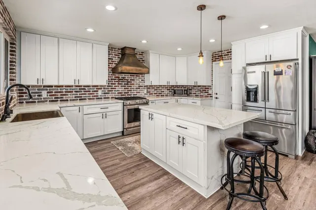 a kitchen with stainless steel appliances granite countertop a sink stove and refrigerator