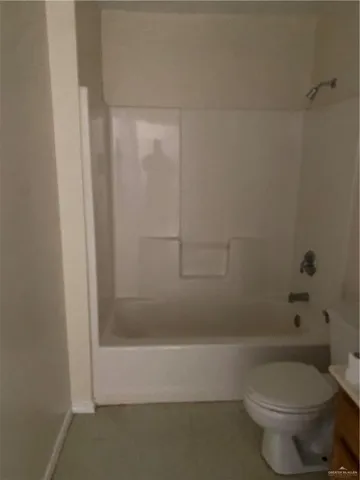 a white toilet sitting next to a bath tub