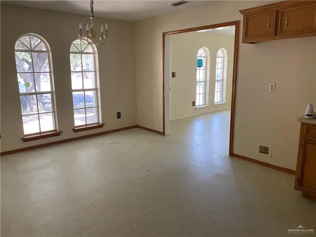 an empty room with windows wooden floor and door