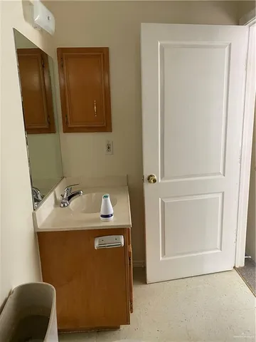 a utility room with a sink and a mirror
