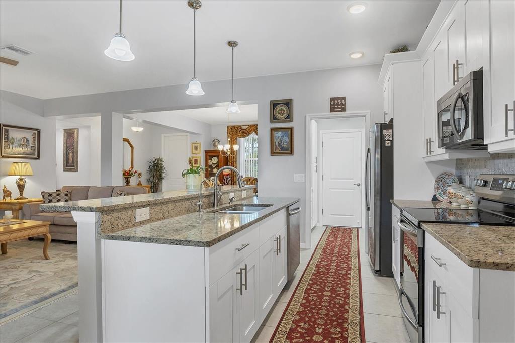 2694 Hopwood Road North Port, FL 34287 - Photo 19 of 56 a kitchen with stainless steel appliances granite countertop a sink stove and refrigerator