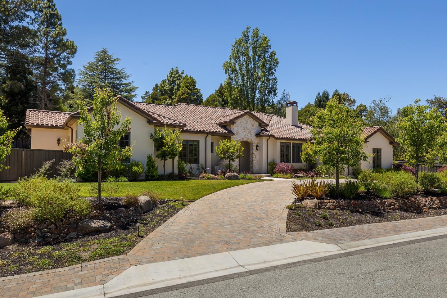 a front view of a house with a yard and potted plants