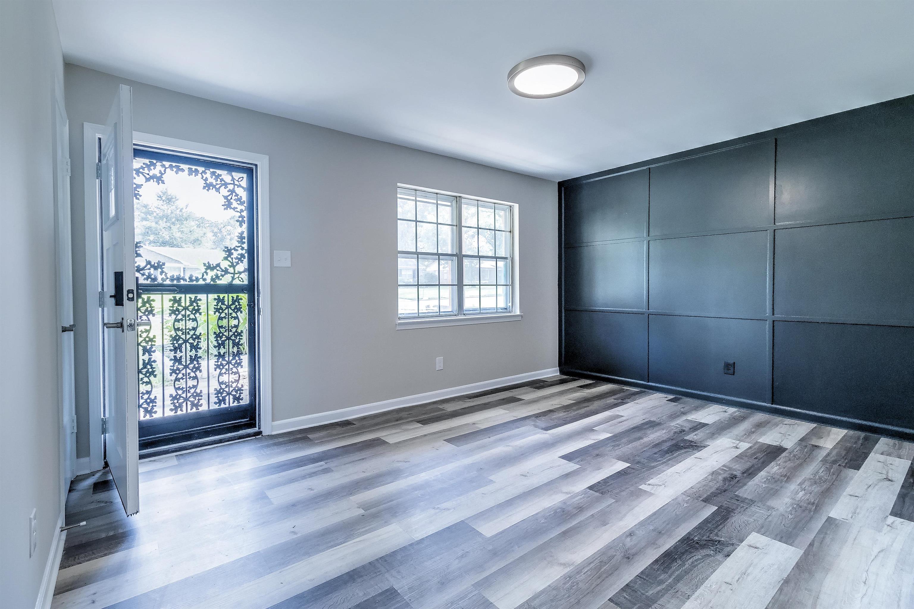1494 Abernathy Road Memphis, TN 38116 - Photo 7 of 35 a view of an empty room with wooden floor and a window