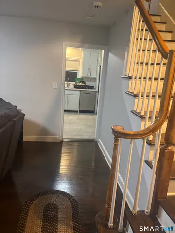 a view of entryway with kitchen and wooden floor