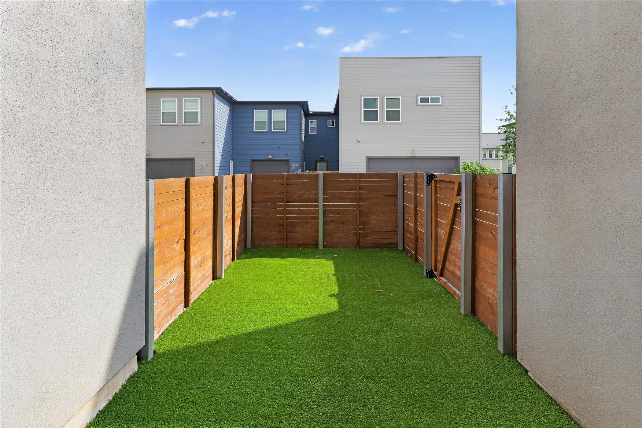 9015 Cattle Baron Path, Unit 1102 Austin, TX 78747 - Photo 22 of 25 Secure, private yard with vibrant green turf, perfect for outdoor enjoyment.