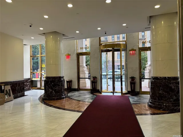 a living room with stainless steel appliances furniture a rug and a view
